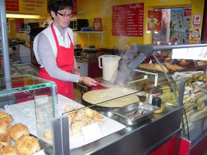 This woman is making a crepe that she will soon slather with chocolate.