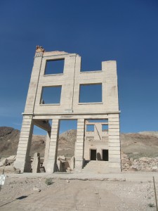 The facade of the old bank building reaches into the desert sky.