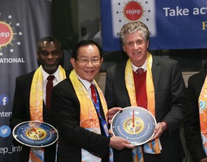 Dr. Hong, Tao-Tze, president of FOWPAL, center, presents the compass clock of conscience, celebrating the United Nations' designation of April 5 as the International Day of Conscience to Rhode Island Lieutenant Governor Daniel Mckee at the UN in New York. (AP Images)